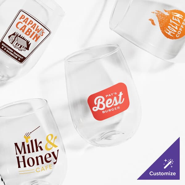 A group of Acopa customizable stemless wine glasses with a logo on one.