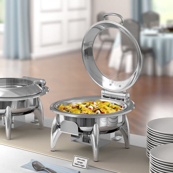 An Acopa Voyage chafer stand with food on a table outdoors.