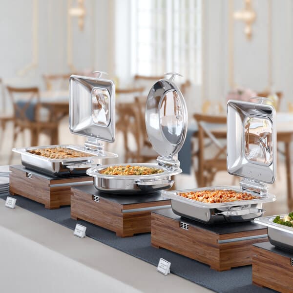 An Acopa stainless steel chafing dish with a soft-close glass lid on a buffet table.