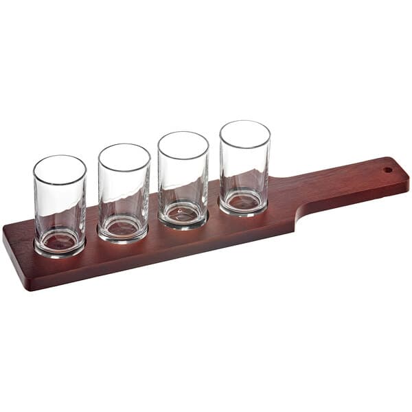 An Acopa mahogany flight paddle with four straight up tasting glasses on it.