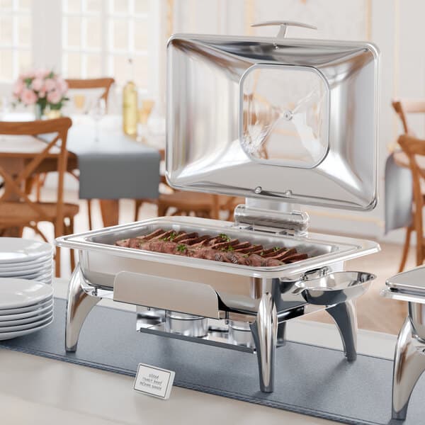 An outdoor buffet table with a stainless steel Acopa Voyage chafer on a stand.