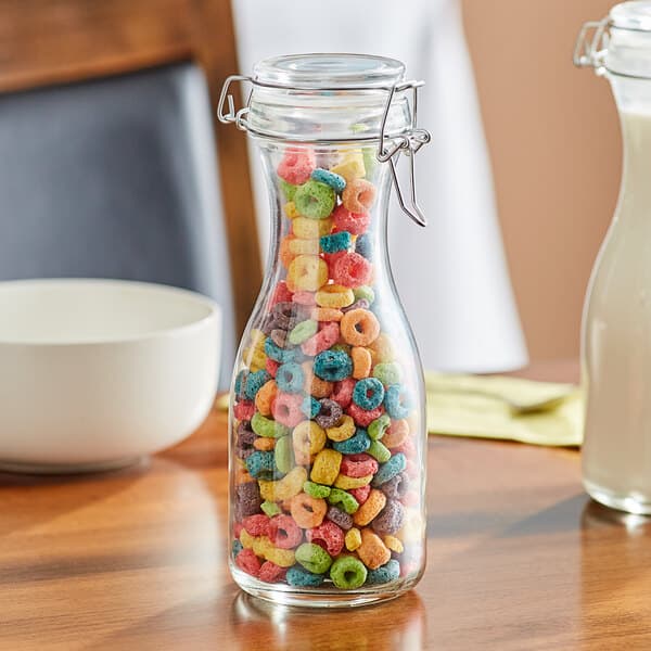 An Acopa glass carafe filled with colorful cereal on a hotel buffet table.