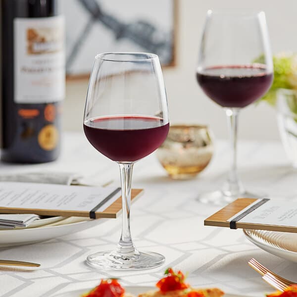 An Acopa Radiance wine glass filled with red wine on a table