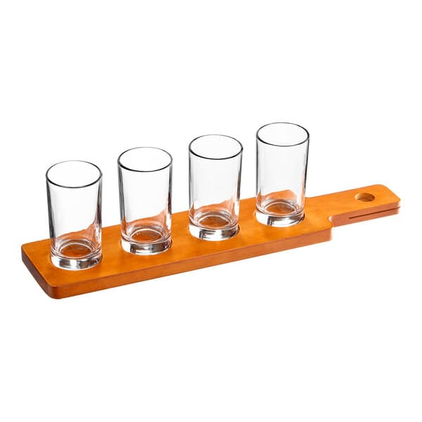 An Acopa wooden flight paddle with four straight up tasting glasses on it.