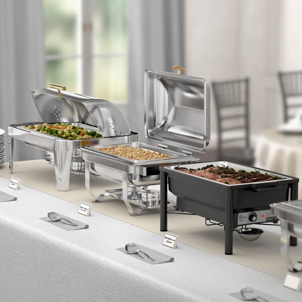 A buffet table with Acopa chafer stands holding food items.