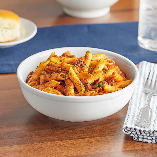 A bowl of pasta with meat sauce and cheese served in an Acopa bright white porcelain bowl.