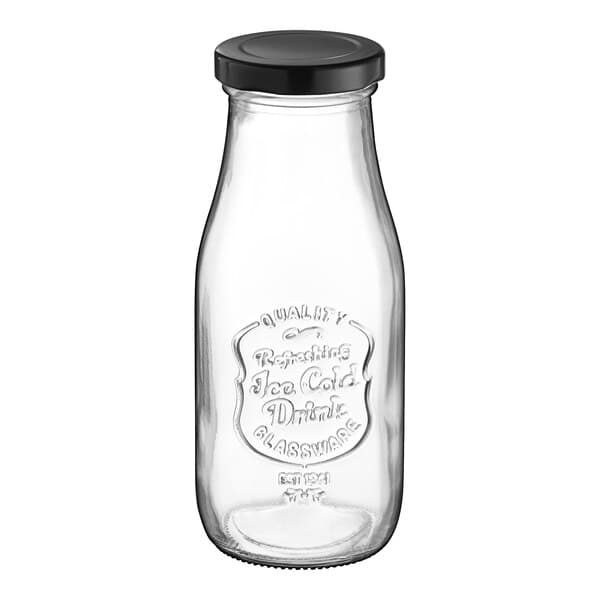 An Acopa glass milk bottle with a black lid.