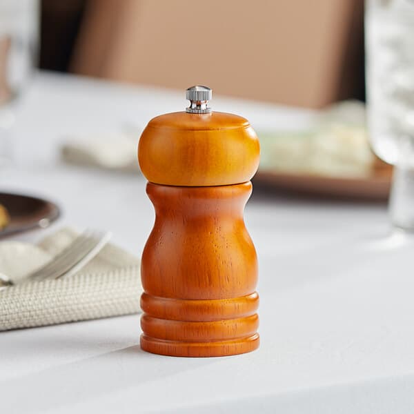 An Acopa wooden pepper mill on a table.