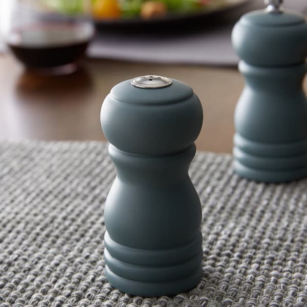 An Acopa wooden salt shaker on a table.