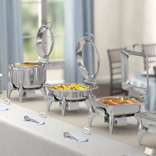 An outdoor buffet table with Acopa Voyage chafers holding food.