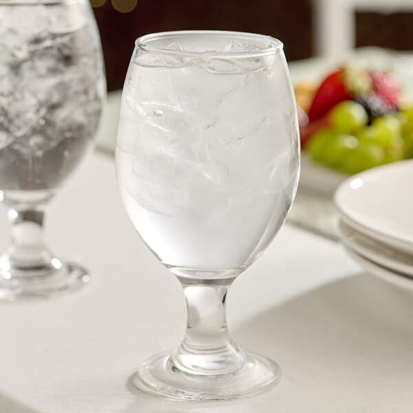 A clear 14 oz. glass goblet filled with ice water.