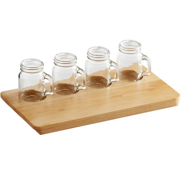 a glass jar with a handle and a brown liquid in it