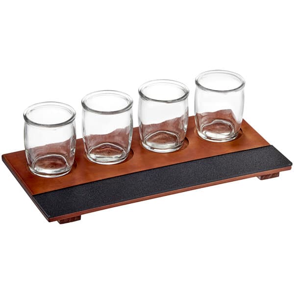 An Acopa wood tray with four rounded tasting glasses on a table.