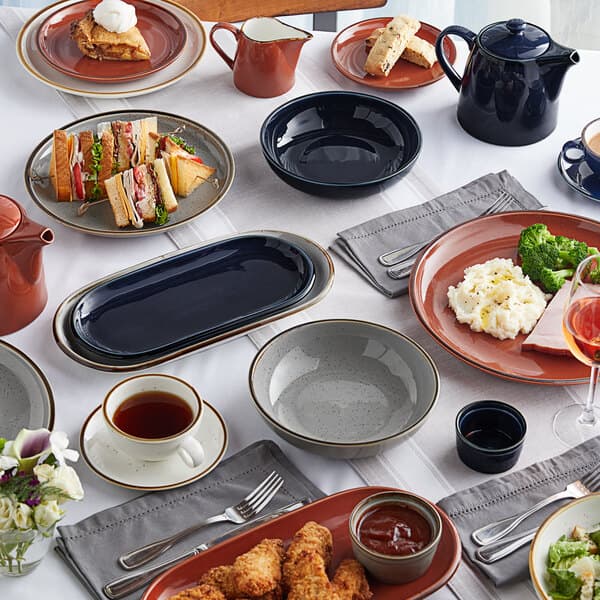 Acopa Keystone mini casserole dishes on a table with plates of food.