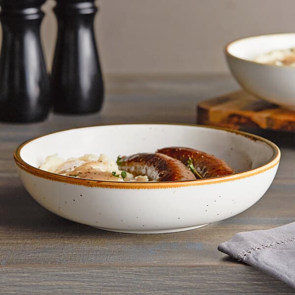 An Acopa Keystone stoneware bowl filled with food on a table.