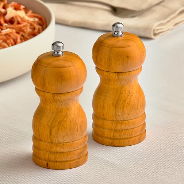 Two Acopa wooden salt and pepper mills on a table.