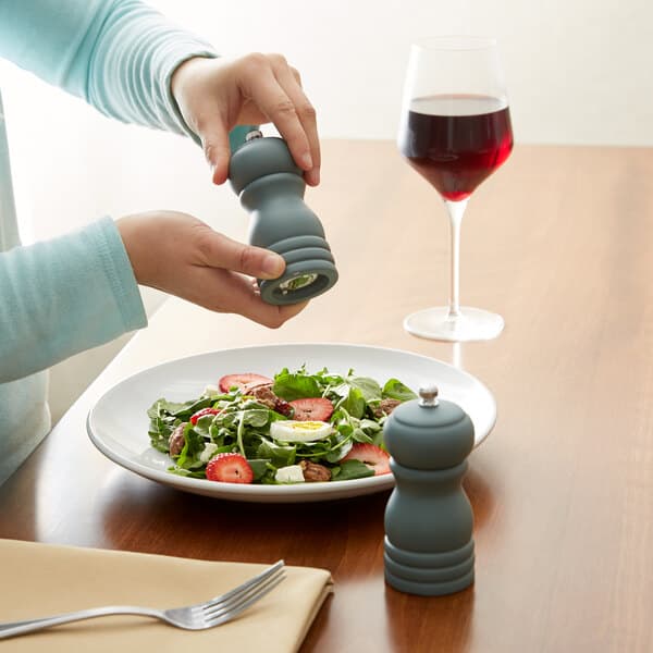 a person holding a pepper grinder