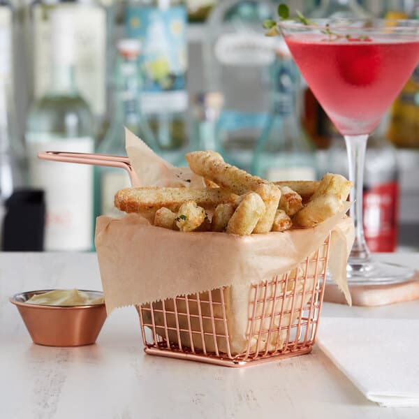 A rose gold square mini fry basket filled with french fries and a drink.
