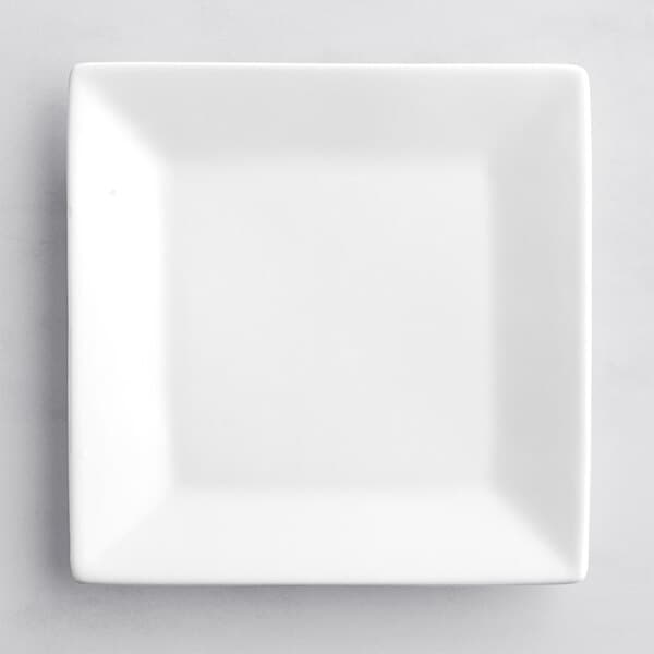 An Acopa bright white square porcelain plate on a white surface.