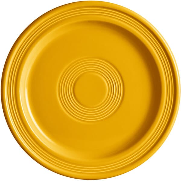 A close up of a mango orange Acopa Capri stoneware plate with a circular pattern in the center.