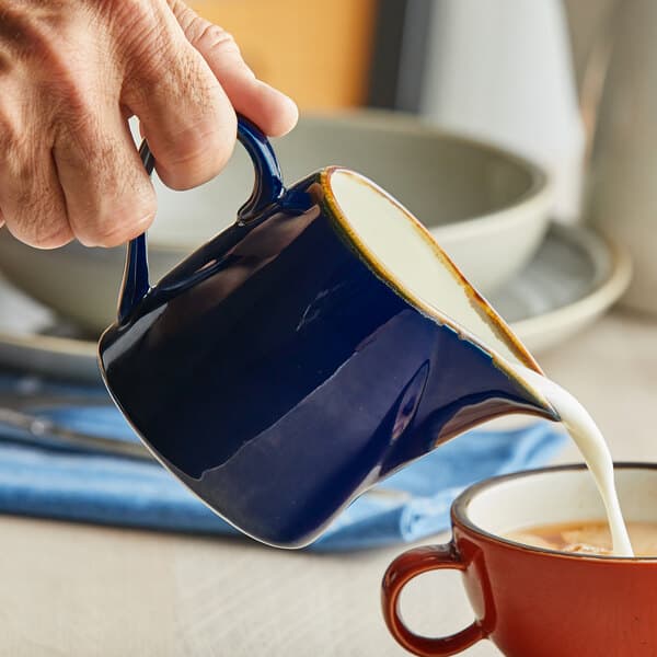 a person holding a blue mug