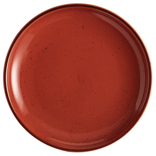 An Acopa Keystone Sedona Orange stoneware coupe plate with speckled specks.