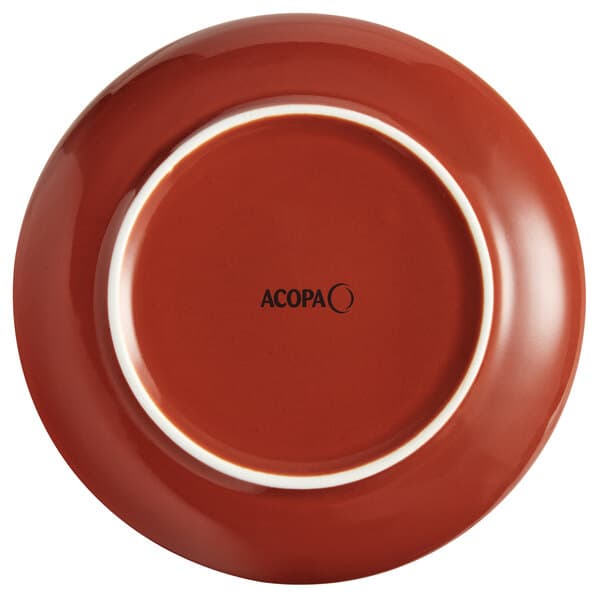 A red stoneware coupe plate with a white rim and the word Acopa in black.
