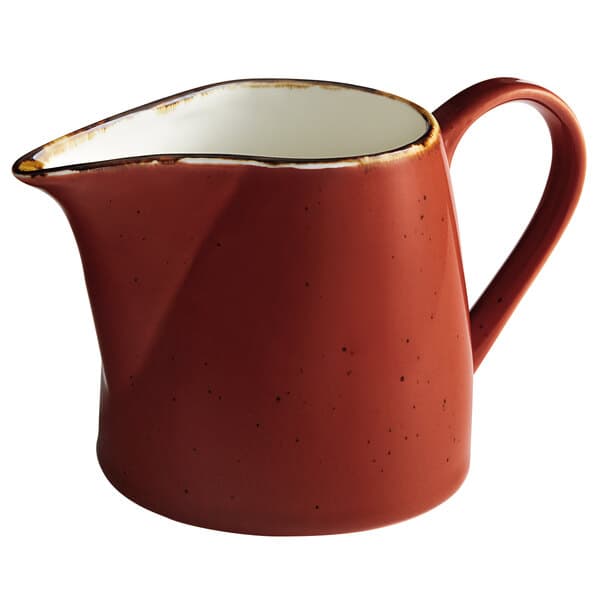 A red pitcher with a white handle.
