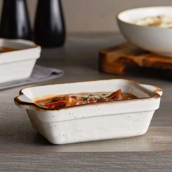 A white Acopa Keystone rectangular casserole dish with food in it.