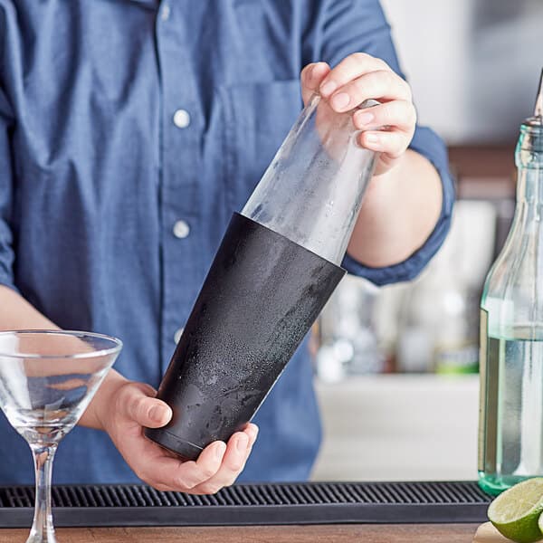 A man using a black Acopa cocktail shaker to make a drink.