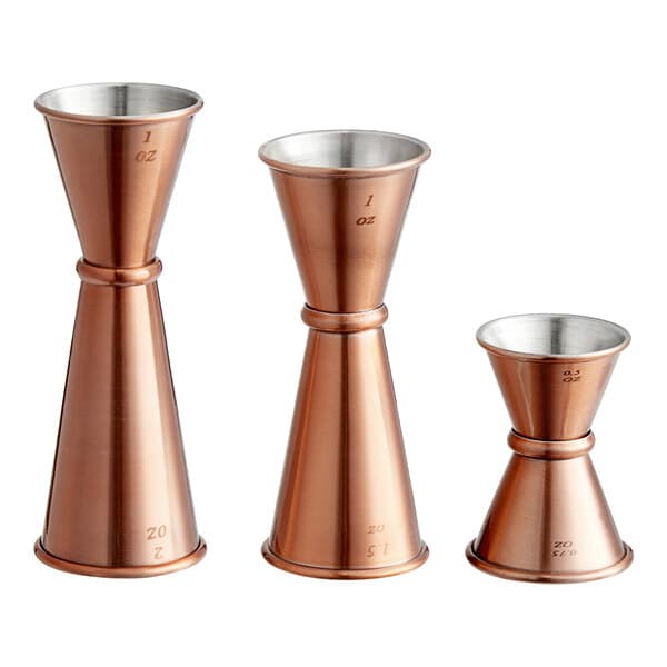 A copper Japanese jigger with two different sizes and shapes.