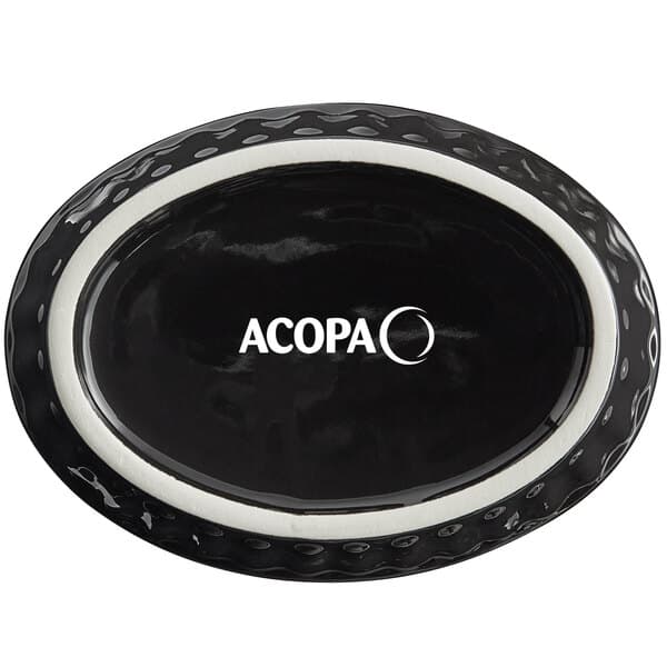 An oval black Acopa stoneware dish with fluted edges and white text.