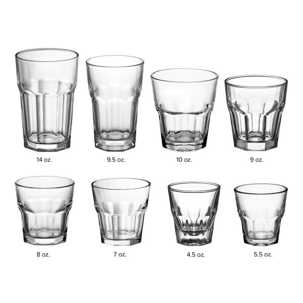 A group of Acopa Memphis clear beverage glasses with curved edges and textured bottoms.