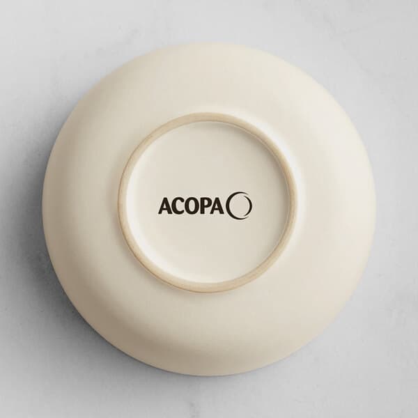 A fog white porcelain bowl with black text that reads "Acopa Pangea" on the side.
