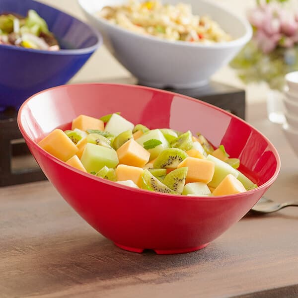 A bowl of fruit salad in a red Acopa melamine bowl.