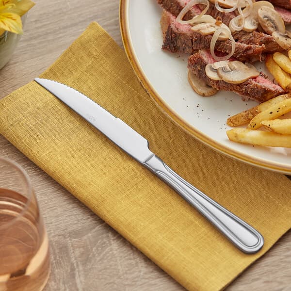 A plate of steak and fries with an Acopa Edgewood steak knife and a glass of wine.