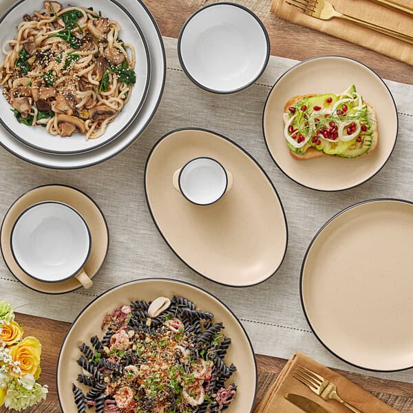 A table set with Acopa Harvest Tan stoneware bowls filled with pasta dishes.