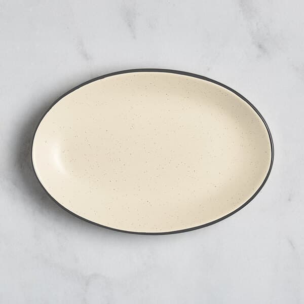 An Acopa cream white stoneware platter with a black rim on an oval shape.