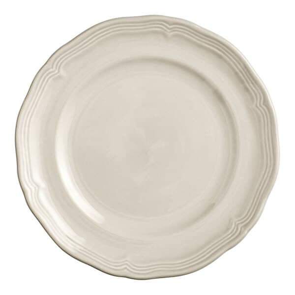 A white Acopa porcelain plate with a scalloped and wide rim.