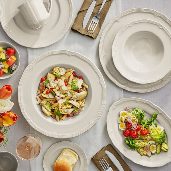 A table set with Acopa Condesa warm gray porcelain plates, bowls, and forks.