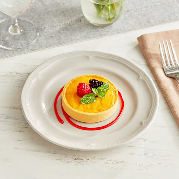 An Acopa Condesa warm gray porcelain plate with a dessert on it.