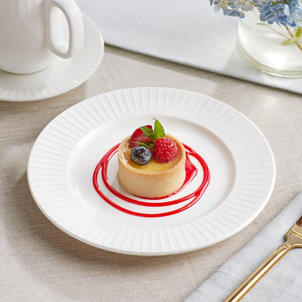 An Acopa Cordelia bright white porcelain plate with a dessert topped with berries.