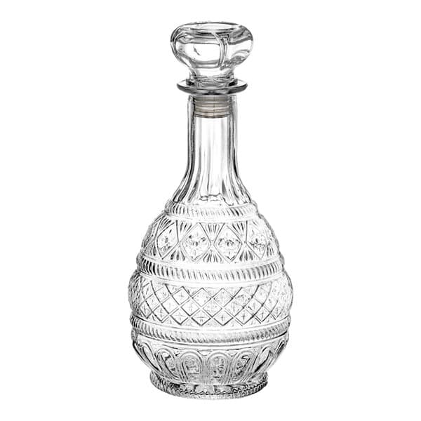 An Acopa clear glass whiskey decanter with a decorative design and a stopper.