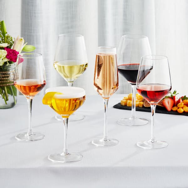 Acopa Silhouette wine glasses filled with red and white wine on a table.