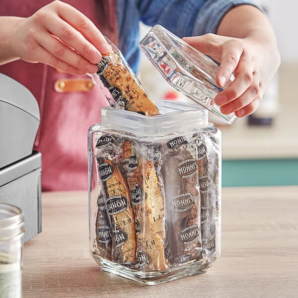 A person using an Acopa clear glass jar to store food.
