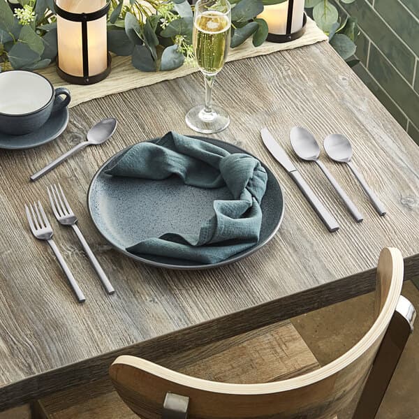 A table set with Acopa Phoenix stainless steel forks and glasses.
