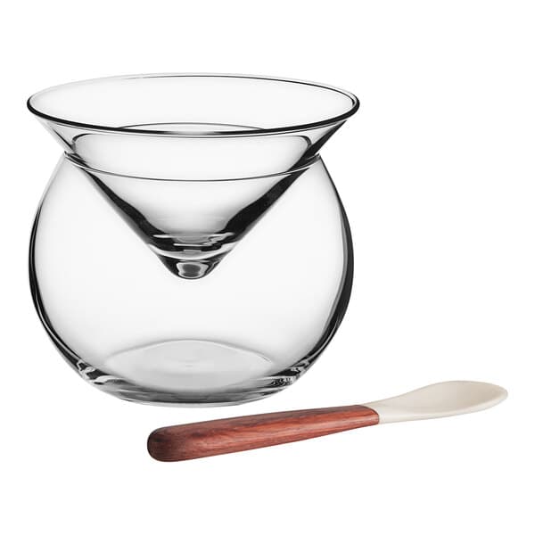 An Acopa glass bowl with a wooden spoon and mother of pearl spoon inside.