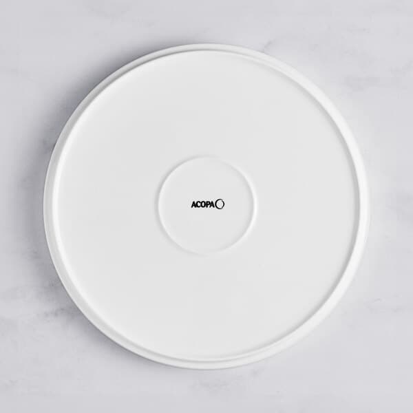 An Acopa Lore bright white porcelain plate with raised rim.