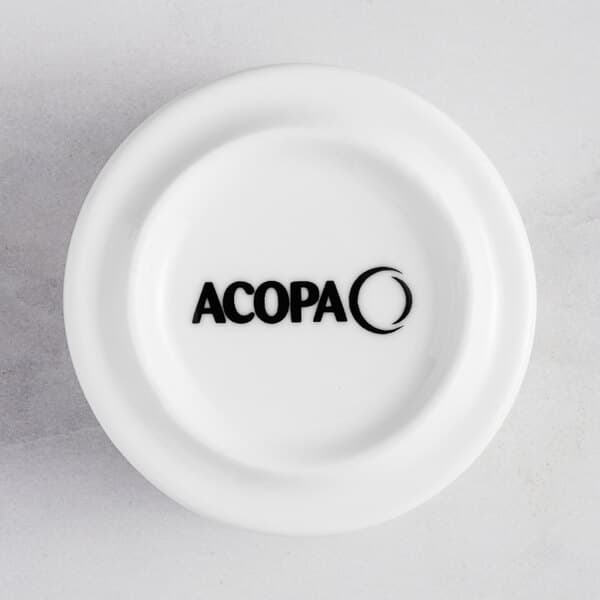 A white porcelain sauce cup with the words "Acopa Lore" in black.