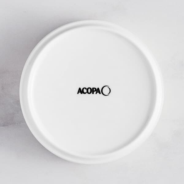 A white Acopa porcelain bowl with raised rim and the word Acopa in black.